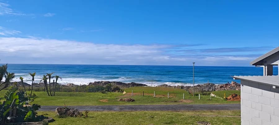 The beach and rocky shoreline below the estate