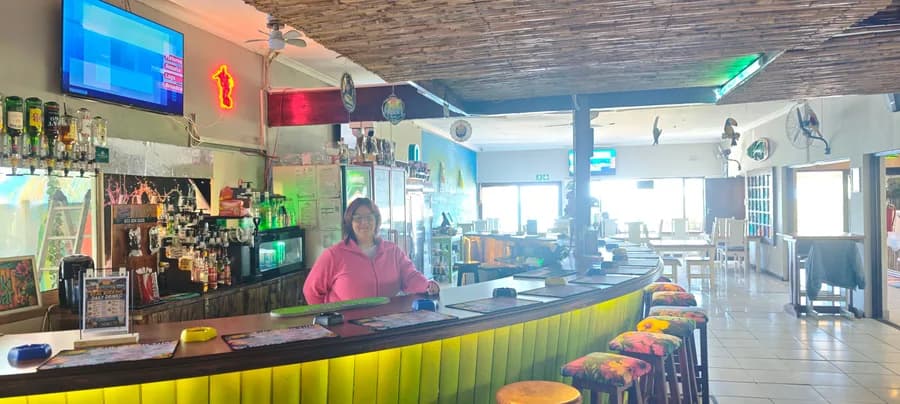 The bar at High Rock Pub & Grill with friendly staff and the sea-facing windows beyond