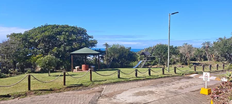 Play area with a jungle gym, slide and shaded lapa