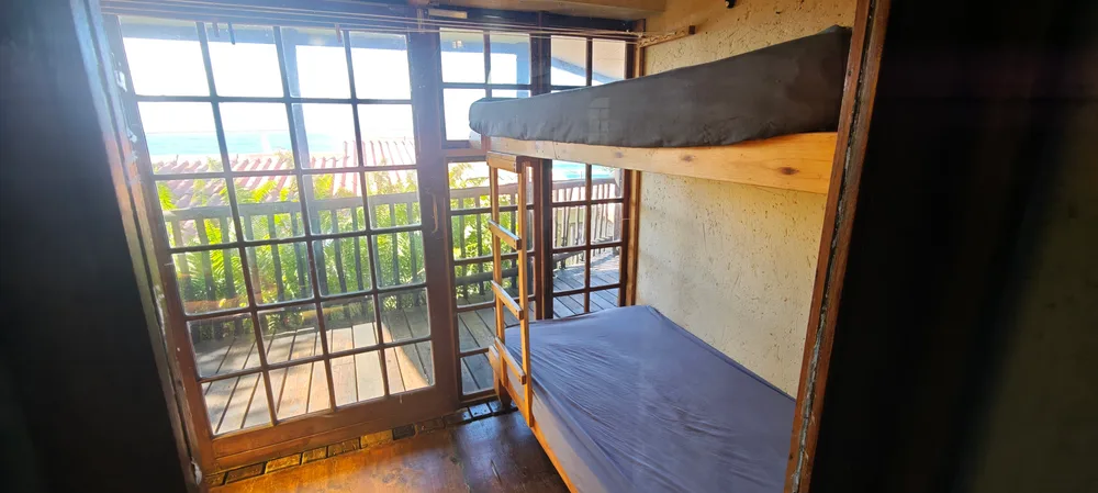 Bunk beds beside doors opening onto the veranda and the sea