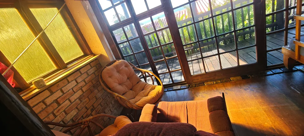 Sun room with wicker chairs and windows onto the veranda