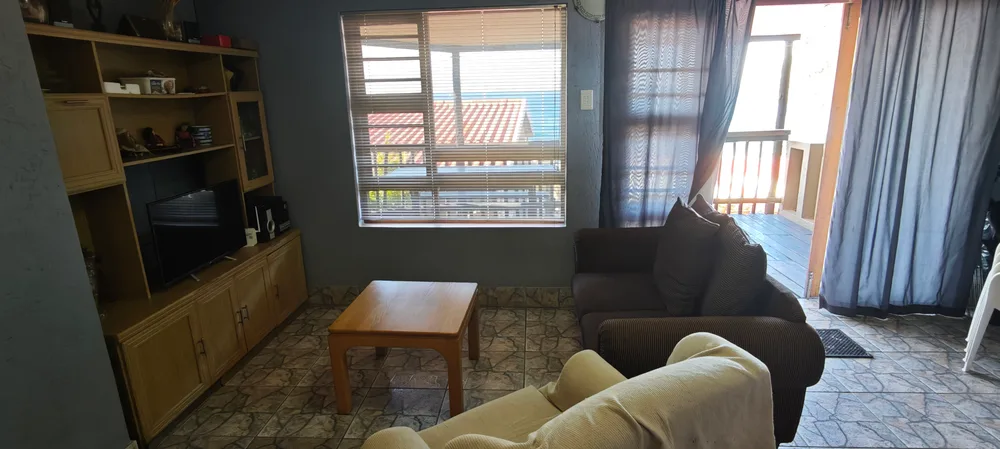 Lounge with couches, a television and a window onto the veranda