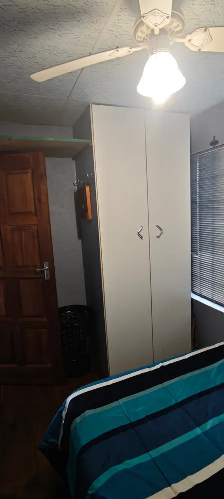 Bedroom with a built-in wardrobe and a ceiling fan