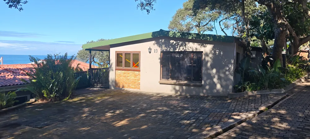 Front of No 19 Grunter Road, with off-street parking and the sea beyond